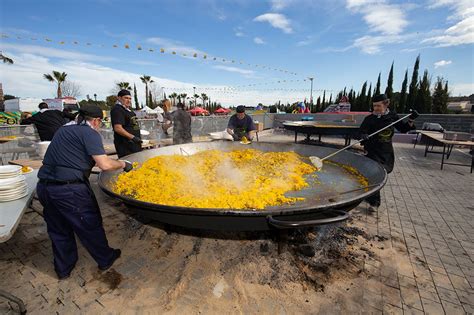 Imagen de una paella gigante siendo servida en un evento al aire libre
